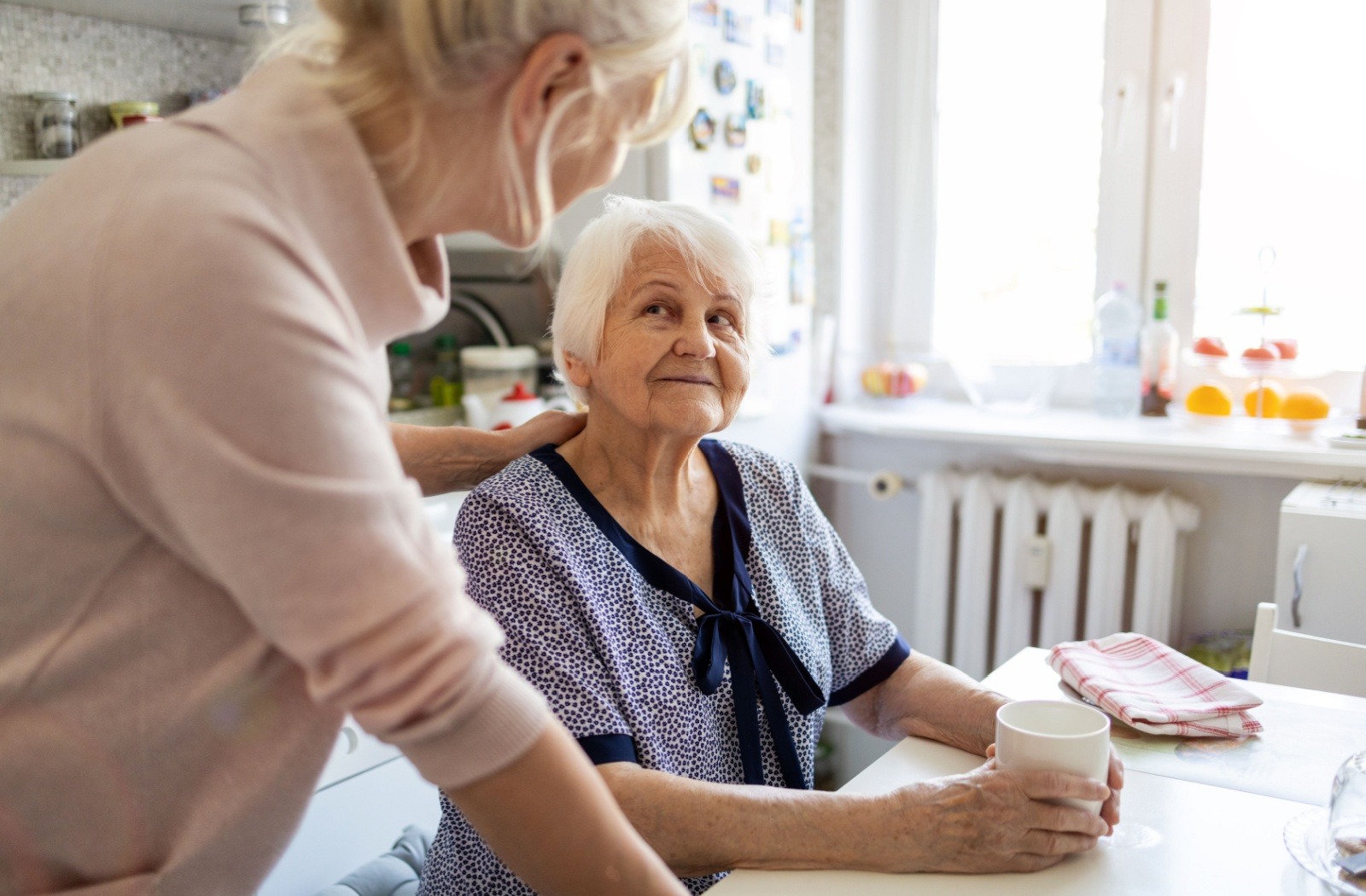 An elderly woman enjoying a conversation with a caregiver