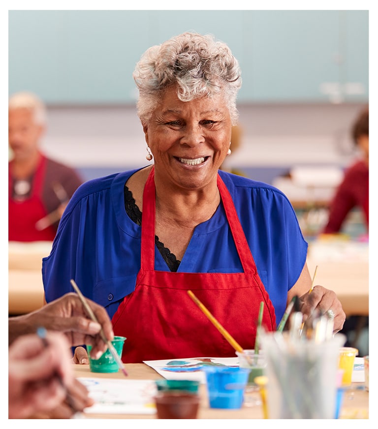 Resident participating in a painting activity with colorful supplies