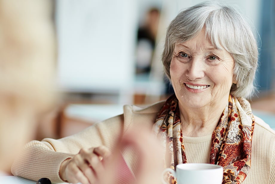 Smiling senior woman enjoying a social moment with coffee