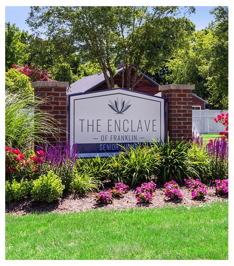 Signage for The Enclave of Franklin surrounded by flowers