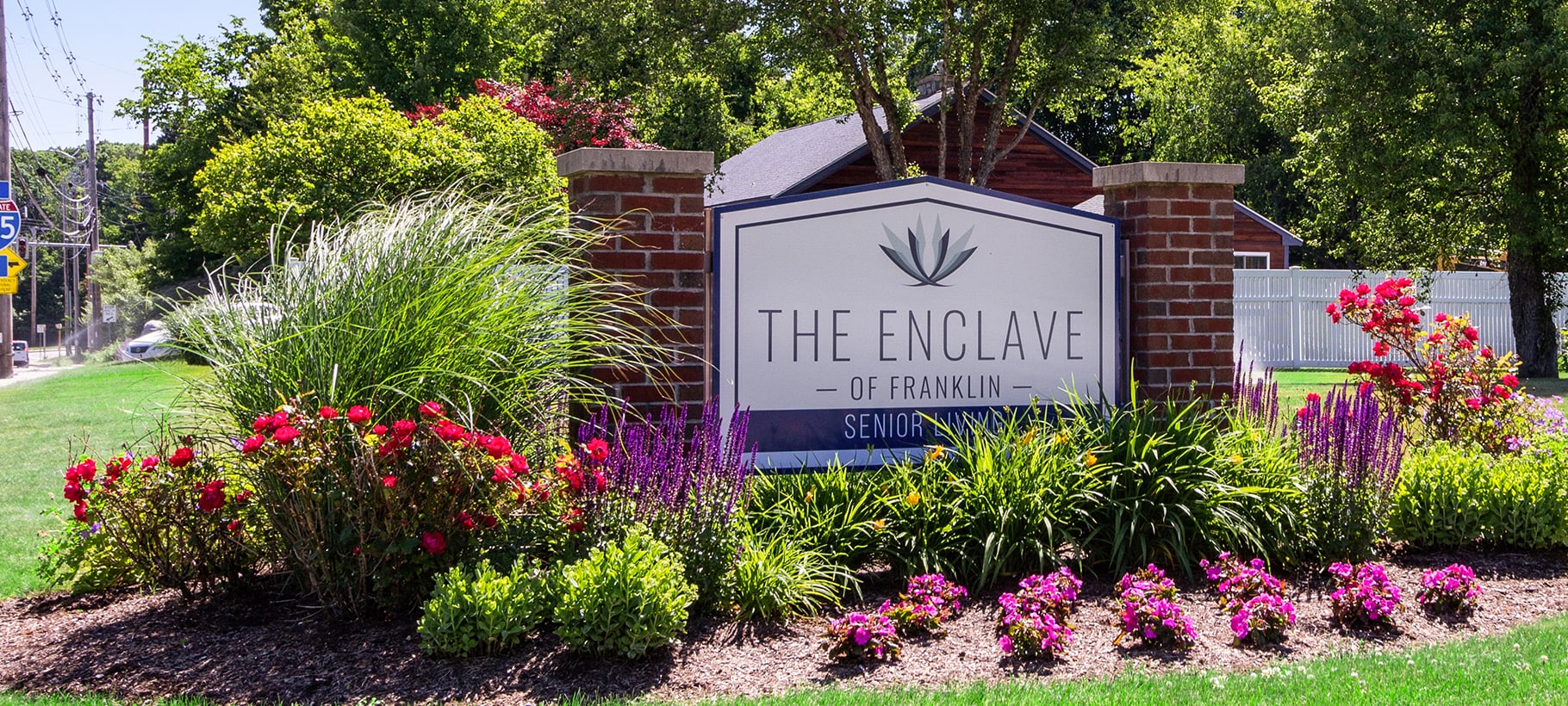 Signage for The Enclave of Franklin in a garden setting.