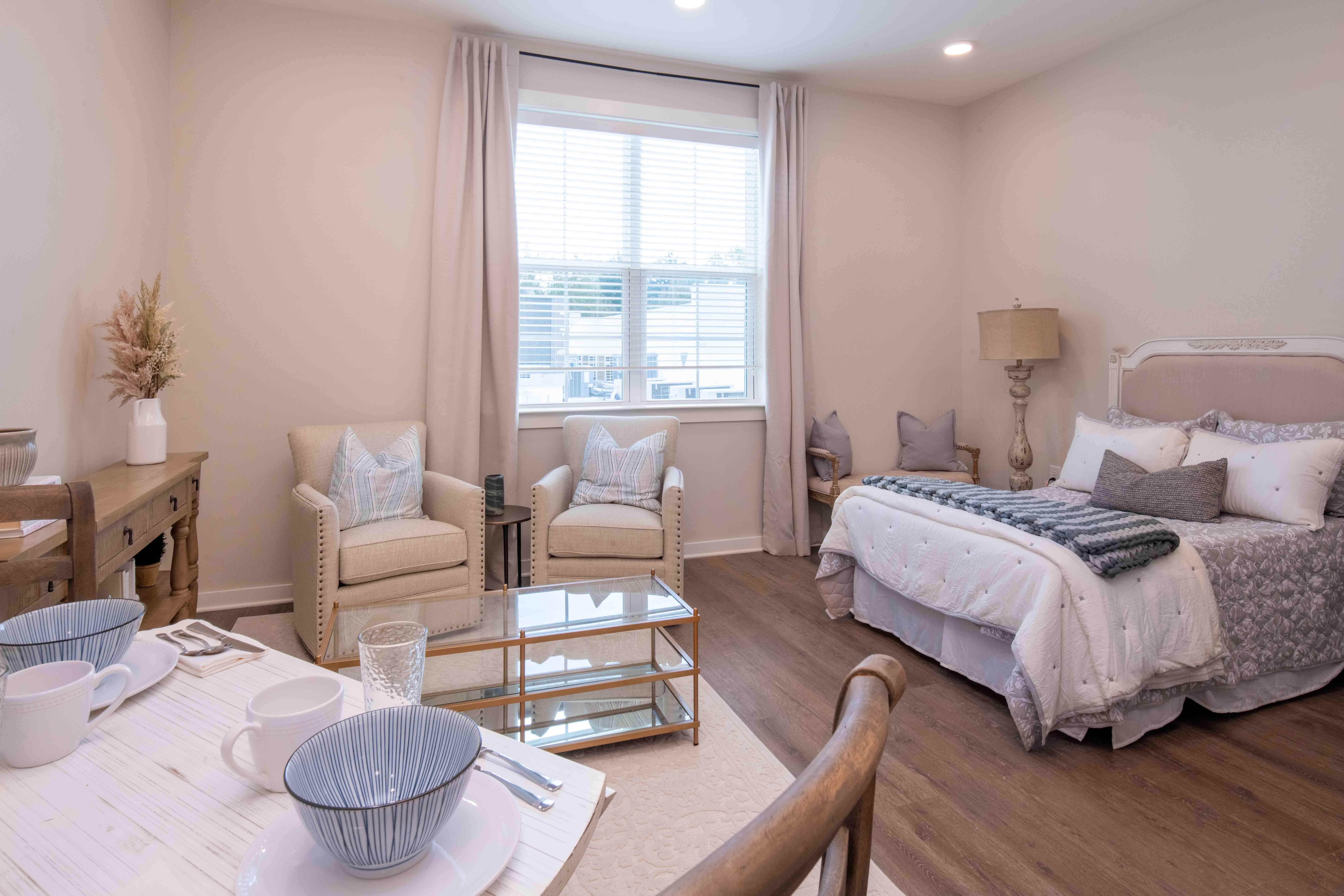 A cozy resident room with a bed and seating area