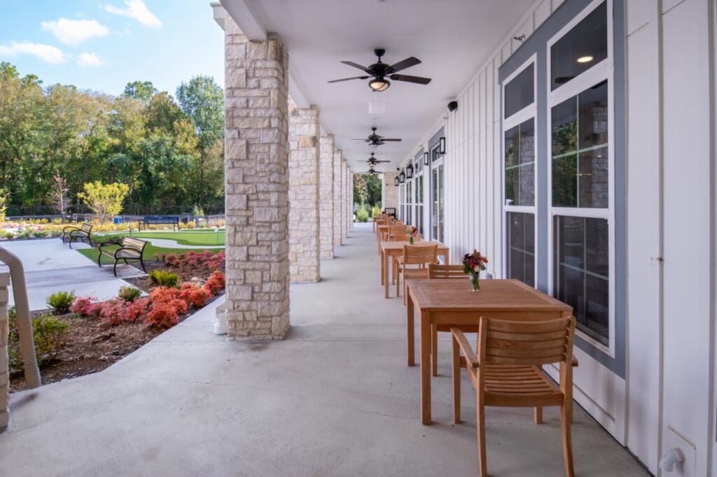 Outdoor area with dining tables and surrounding garden