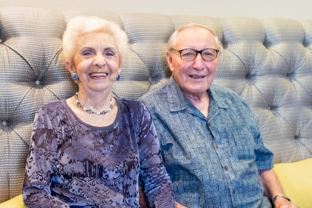 Elderly couple smiling together in a cozy seating area