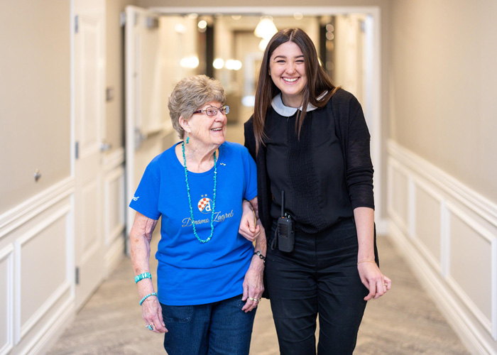 Resident and staff member walking together in a hallway