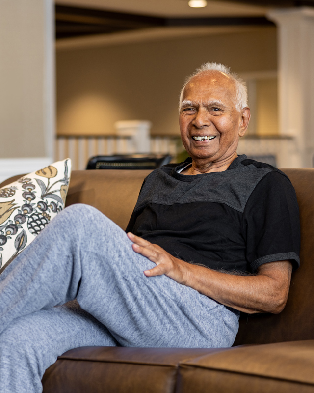 Happy resident sitting on a couch in a common area