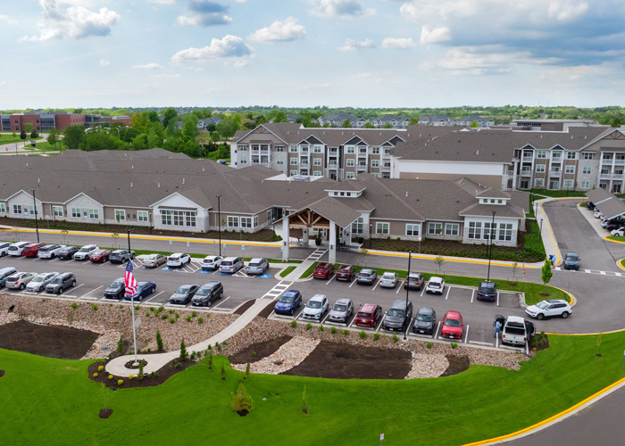 Aerial view of a senior living facility with parking and landscaped grounds