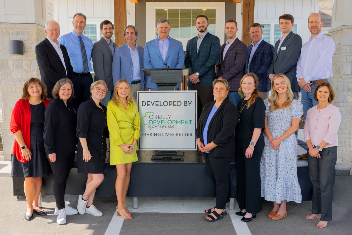 Group photo of staff members in front of the facility