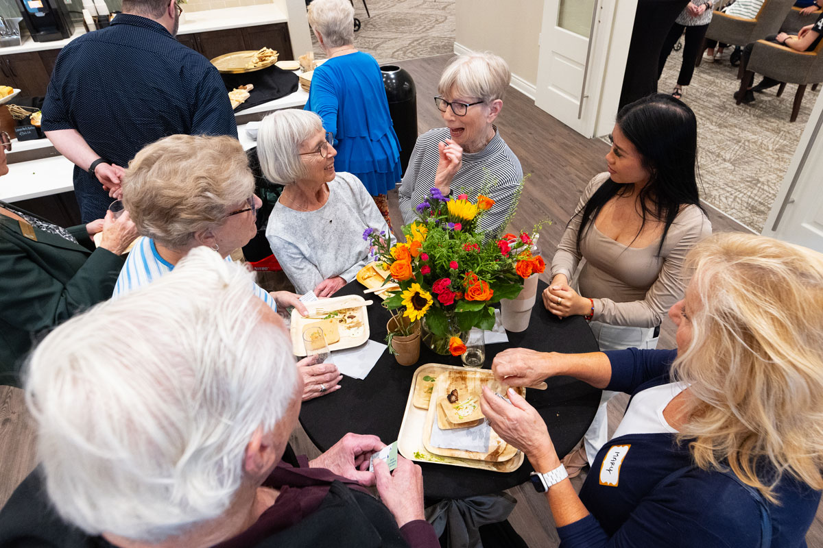 Residents enjoying conversation with food and flowers