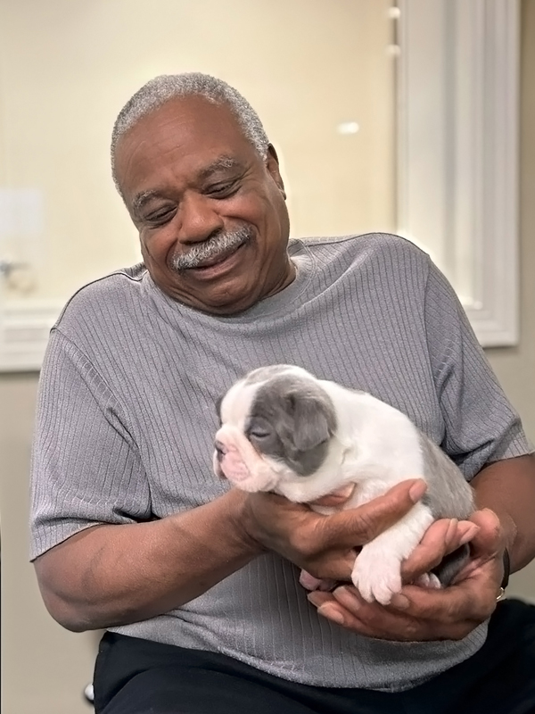Resident gently holding a puppy, sharing a moment of joy