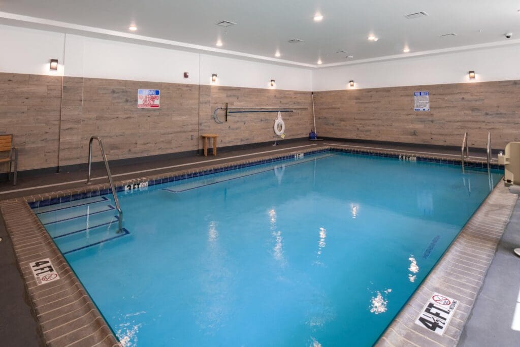 Indoor swimming pool area with blue water and wood paneling