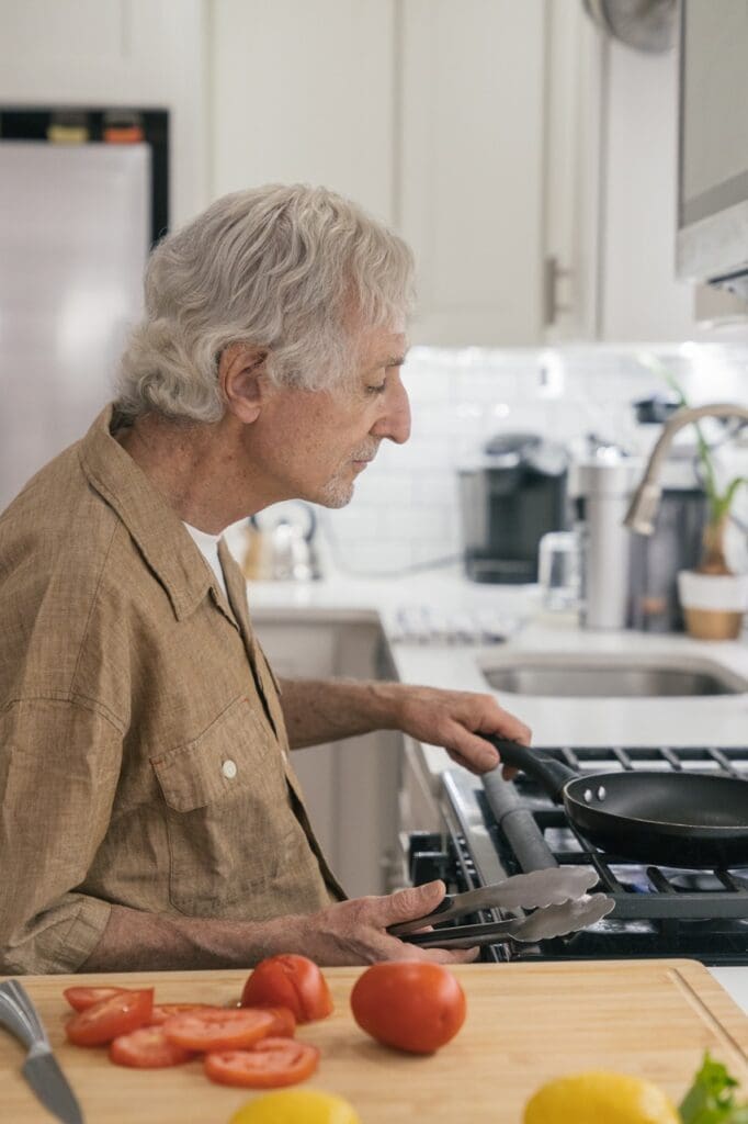 Older man cooking in a well-lit kitchen