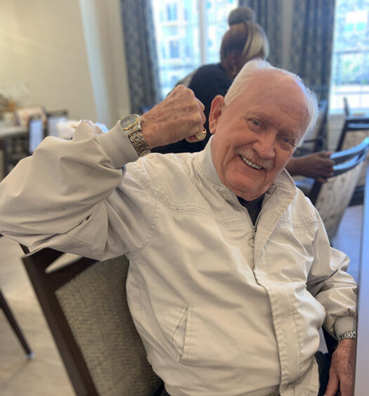 Senior resident smiling and engaging in a common area