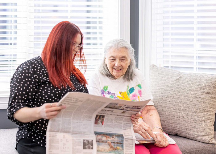 Two residents enjoying a newspaper in a cozy sitting area