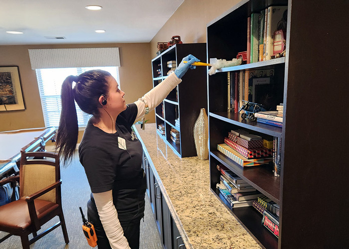 Staff member cleaning a shelf in a common area