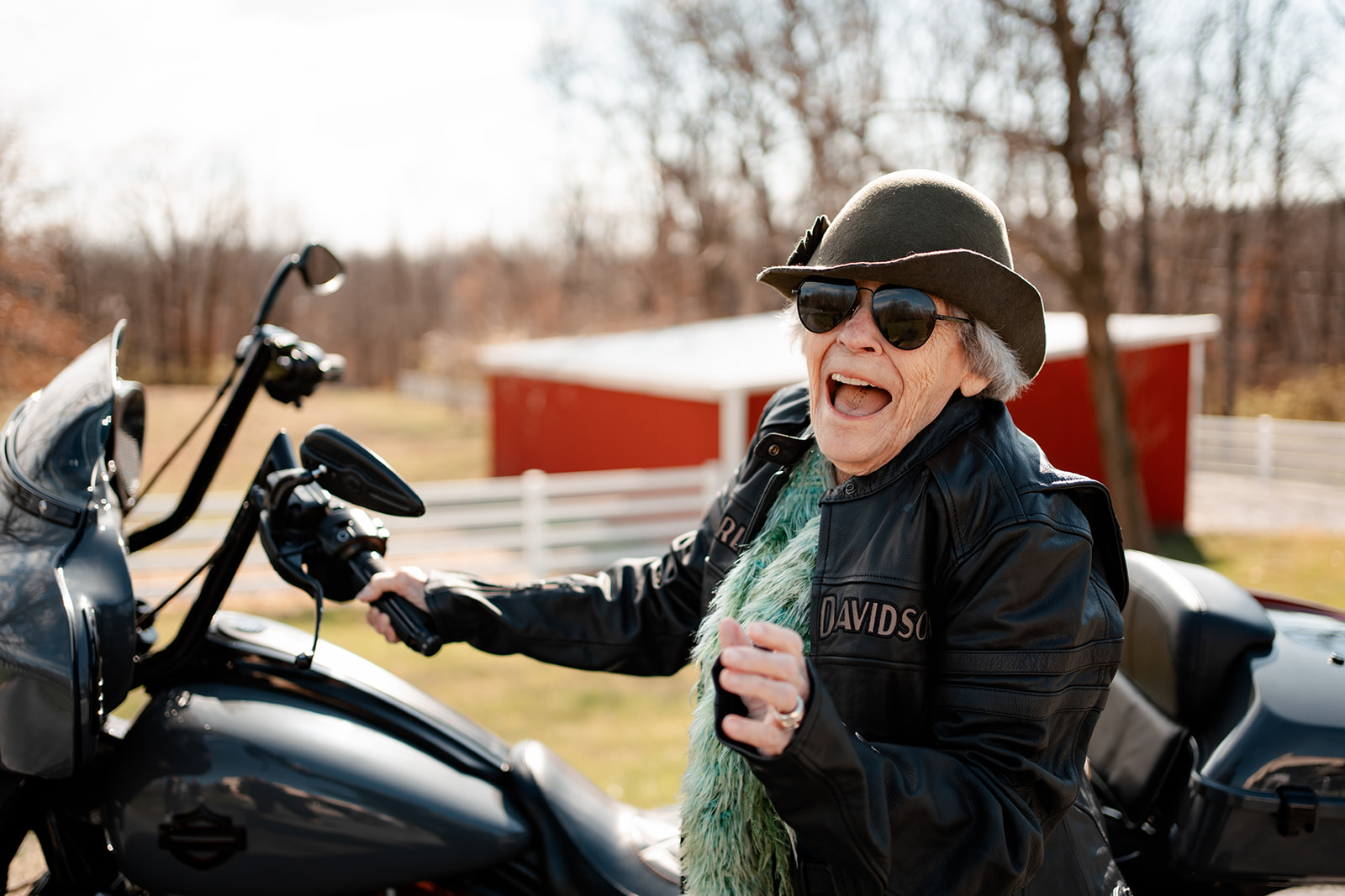 Senior resident joyfully next to a motorcycle in a sunny outdoor space