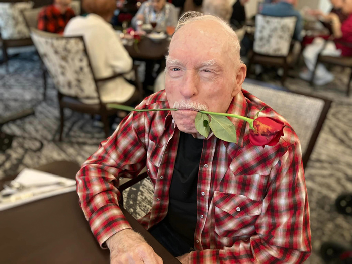 Resident enjoying a rose in a common area