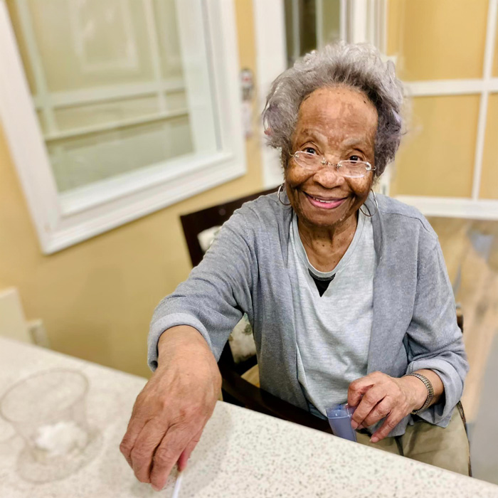 Elderly resident smiling at a table