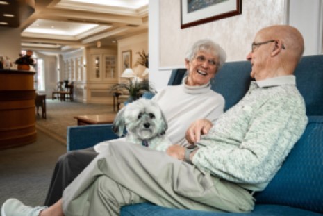 Residents enjoying conversation with a dog in a common area