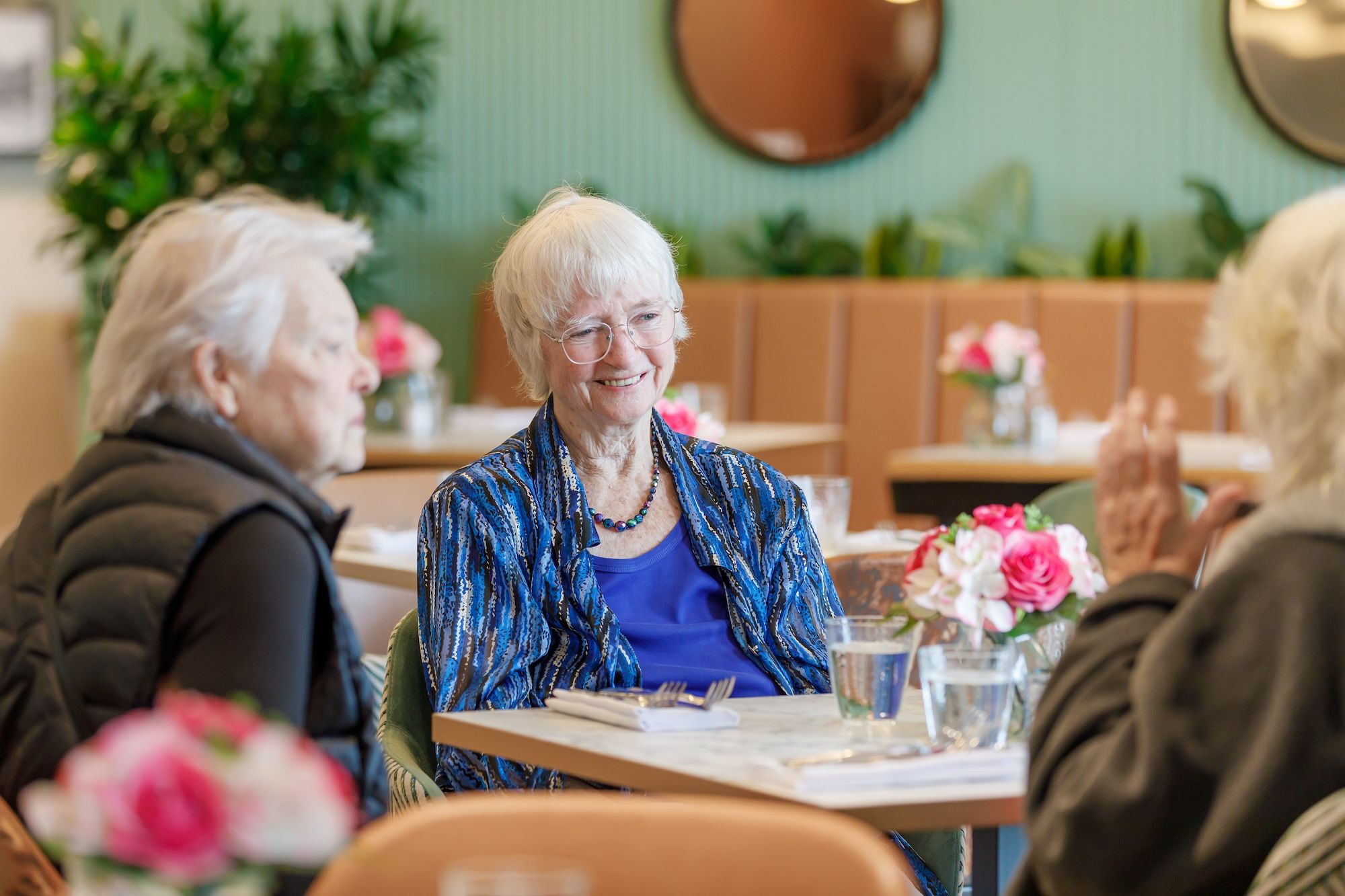 Residents enjoying conversation in a bright dining room