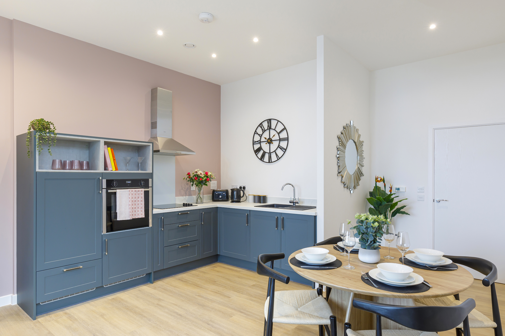 Bright kitchen area with dining table set for residents