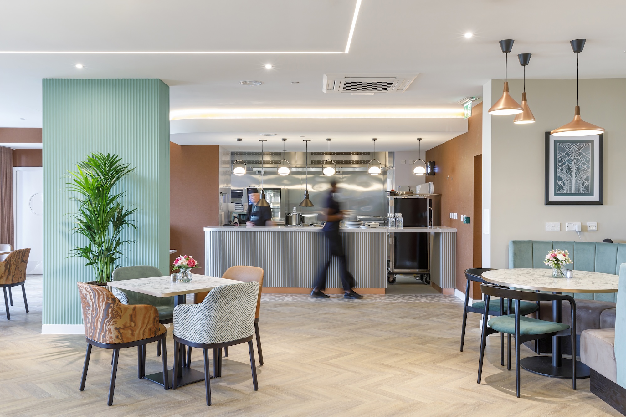 Interior view of a dining area with staff and plants