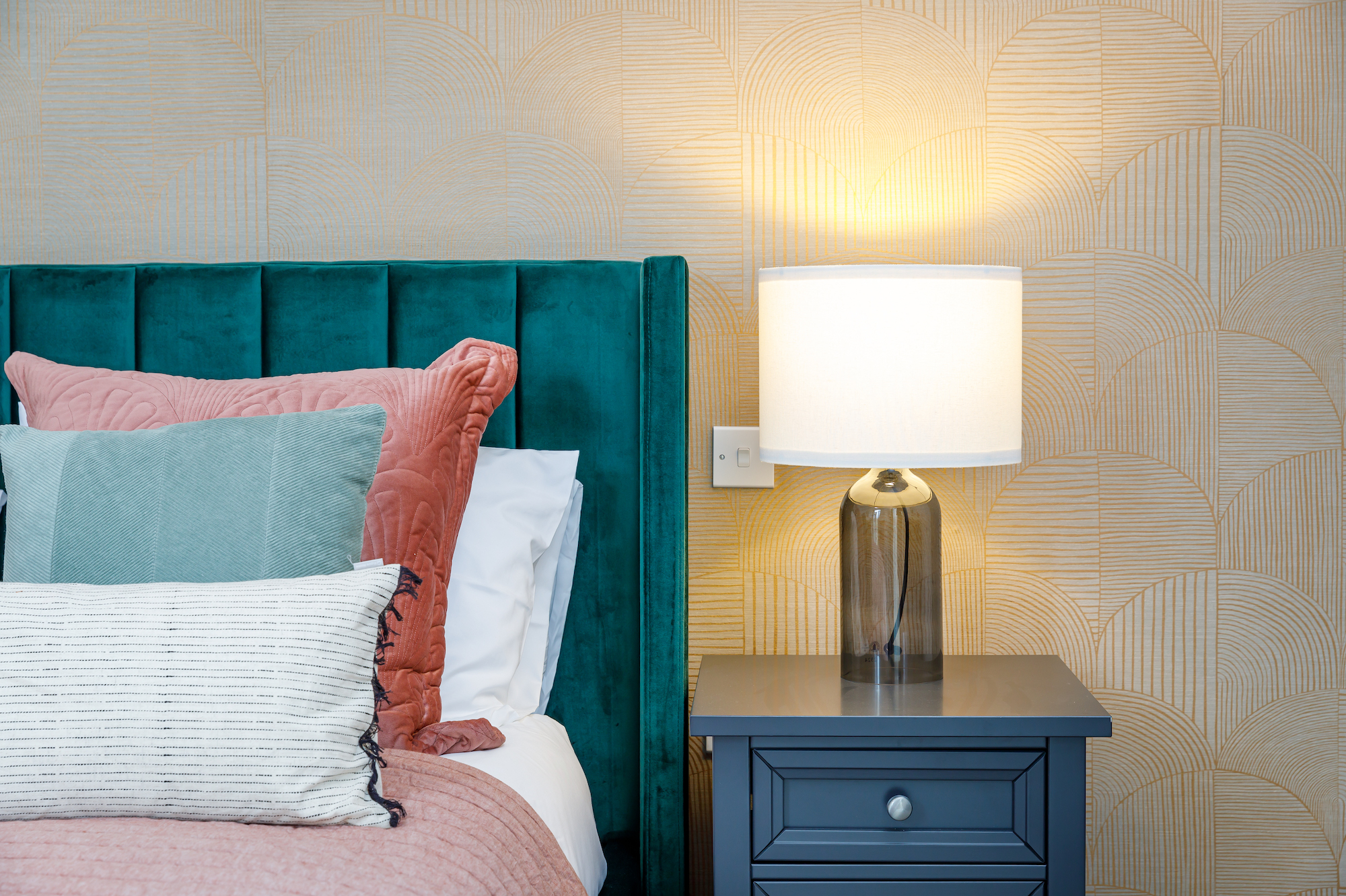 Cozy bedroom setup with a green headboard and lamp