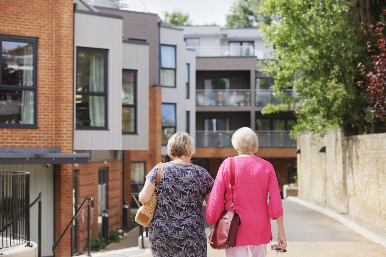 Two residents walking outside in a senior living community