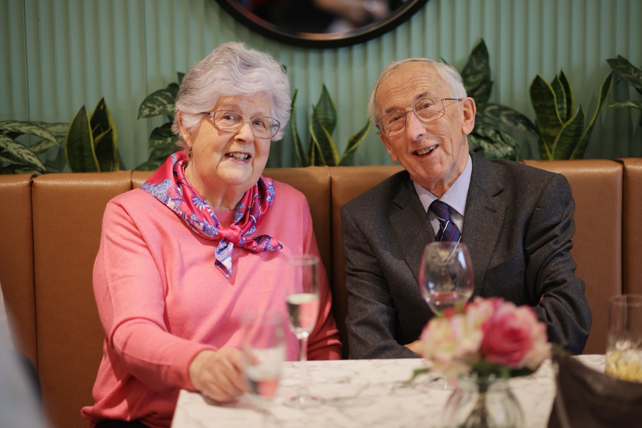Two seniors enjoying a meal in a dining area