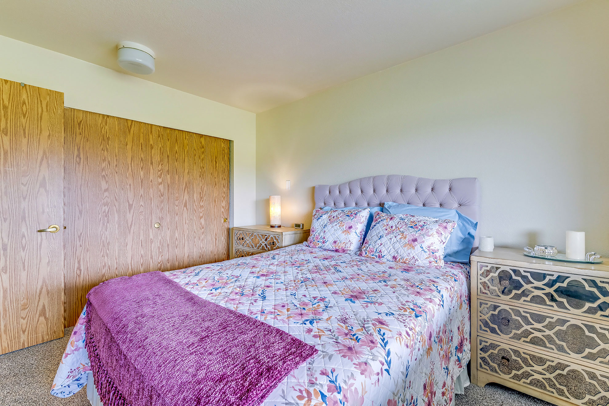 Cozy bedroom with floral bedding and wooden furniture