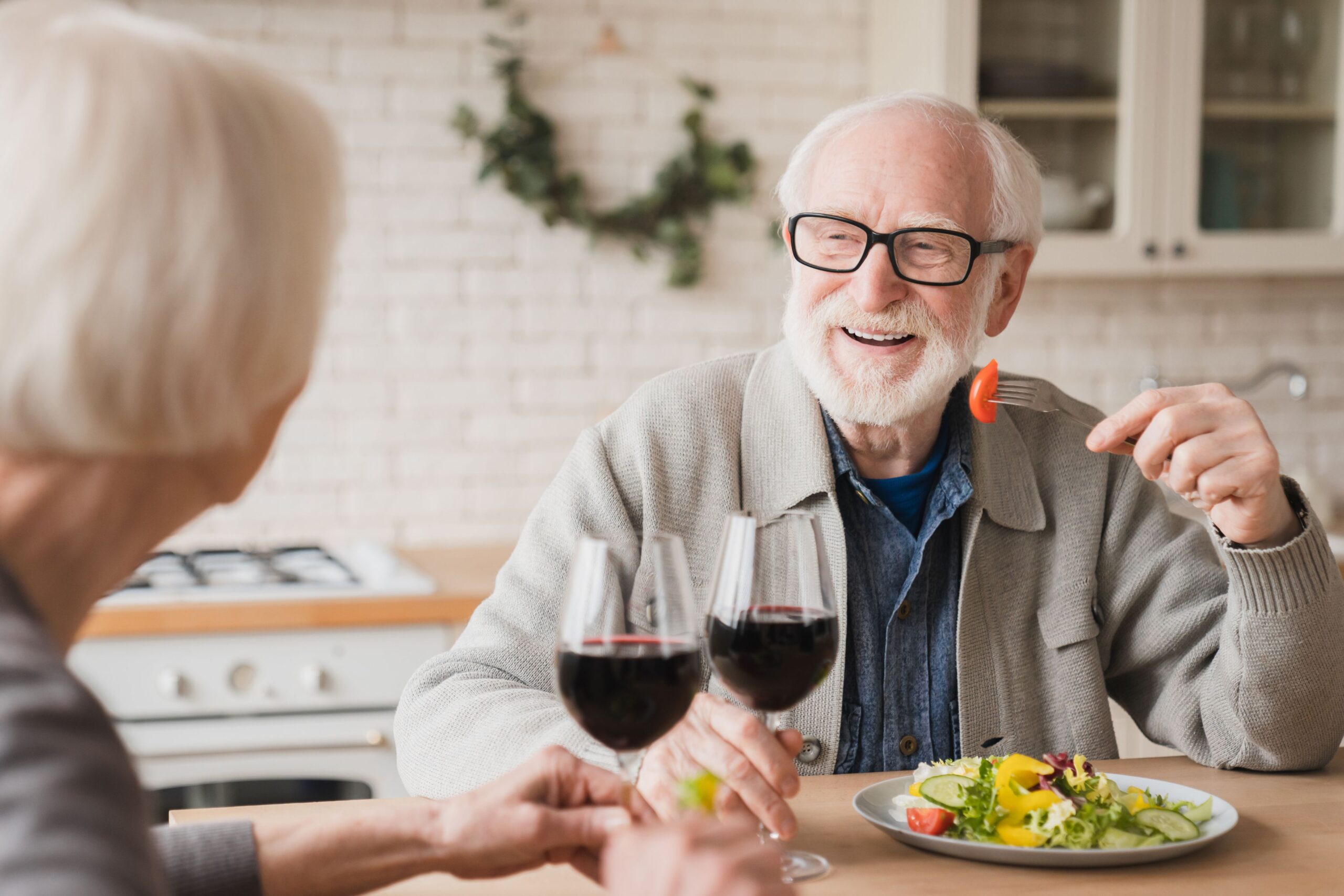 Seniors enjoying a meal together with wine