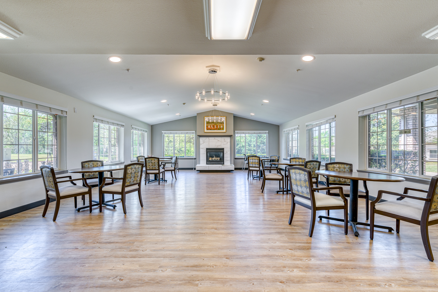 Bright common area with tables and chairs for residents