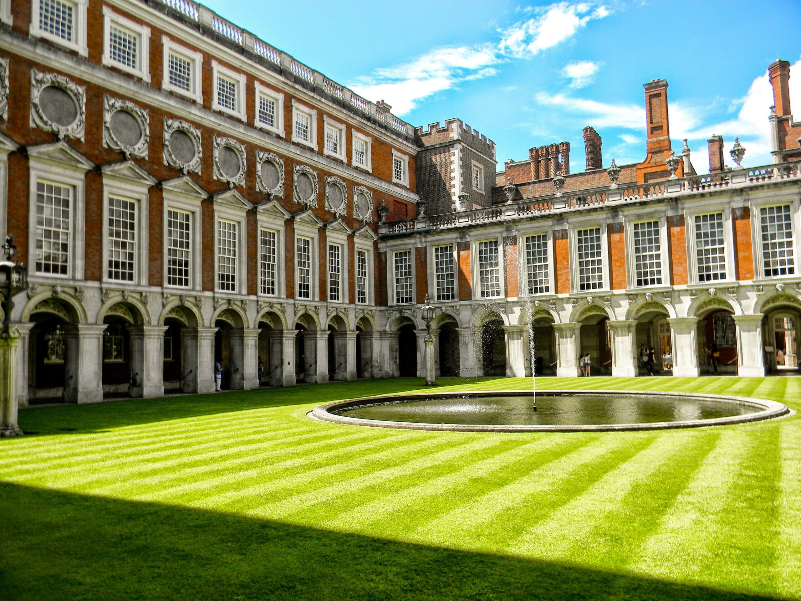 A landscaped courtyard with grass and historical architecture