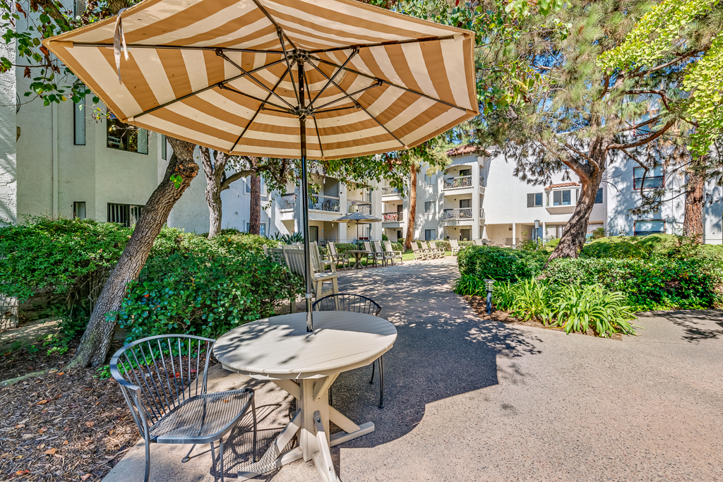 Outdoor seating area with an umbrella and greenery