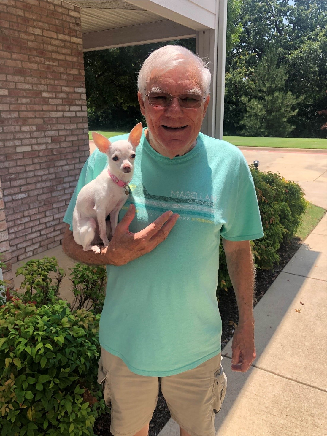 A resident holding a small dog outside the facility
