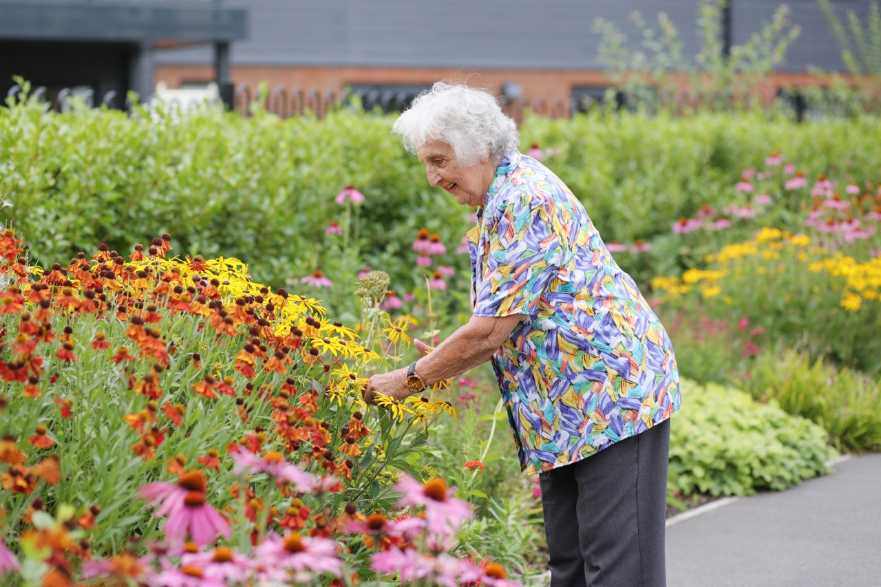 Senior woman enjoying a beautiful flower garden