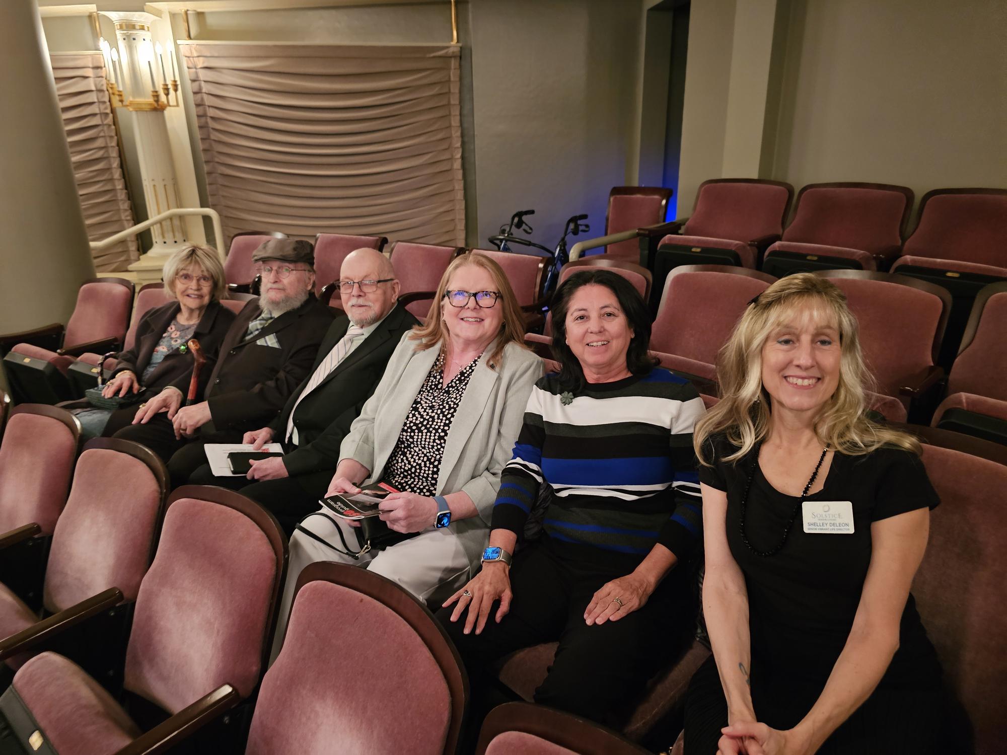 Residents and staff enjoying an event in a theater
