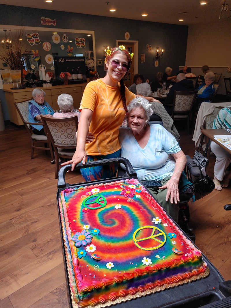 Staff member with resident and a decorated cake