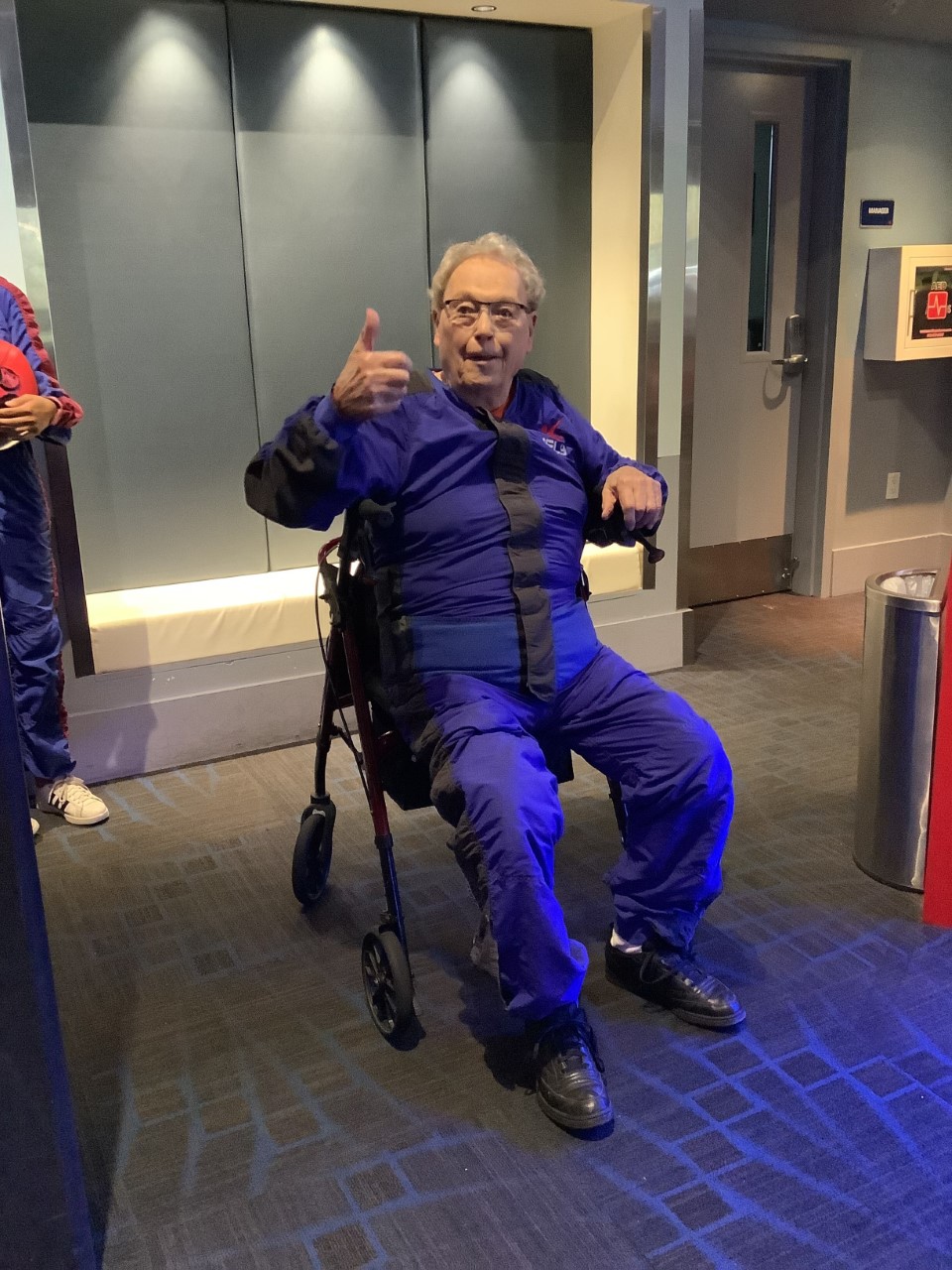 Senior resident giving a thumbs up in a vibrant setting.
