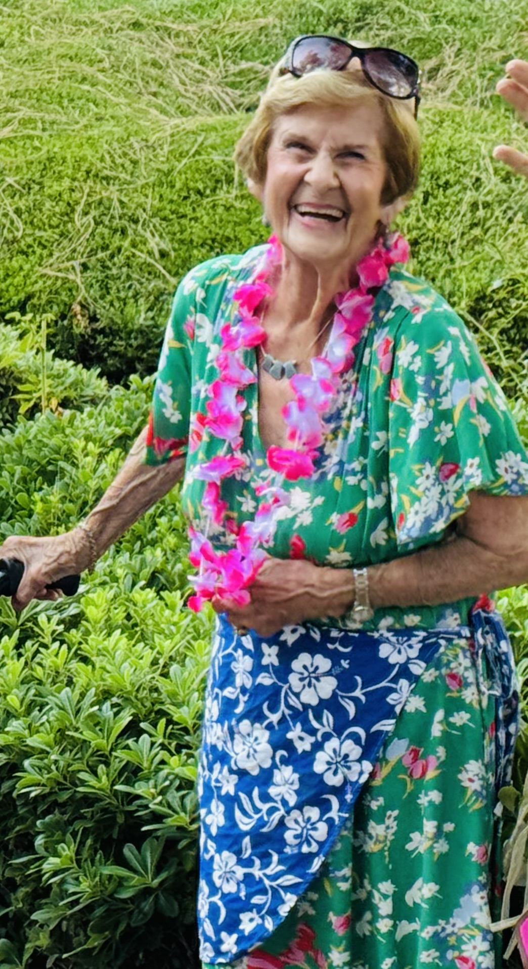 Resident smiling outdoors in a garden setting