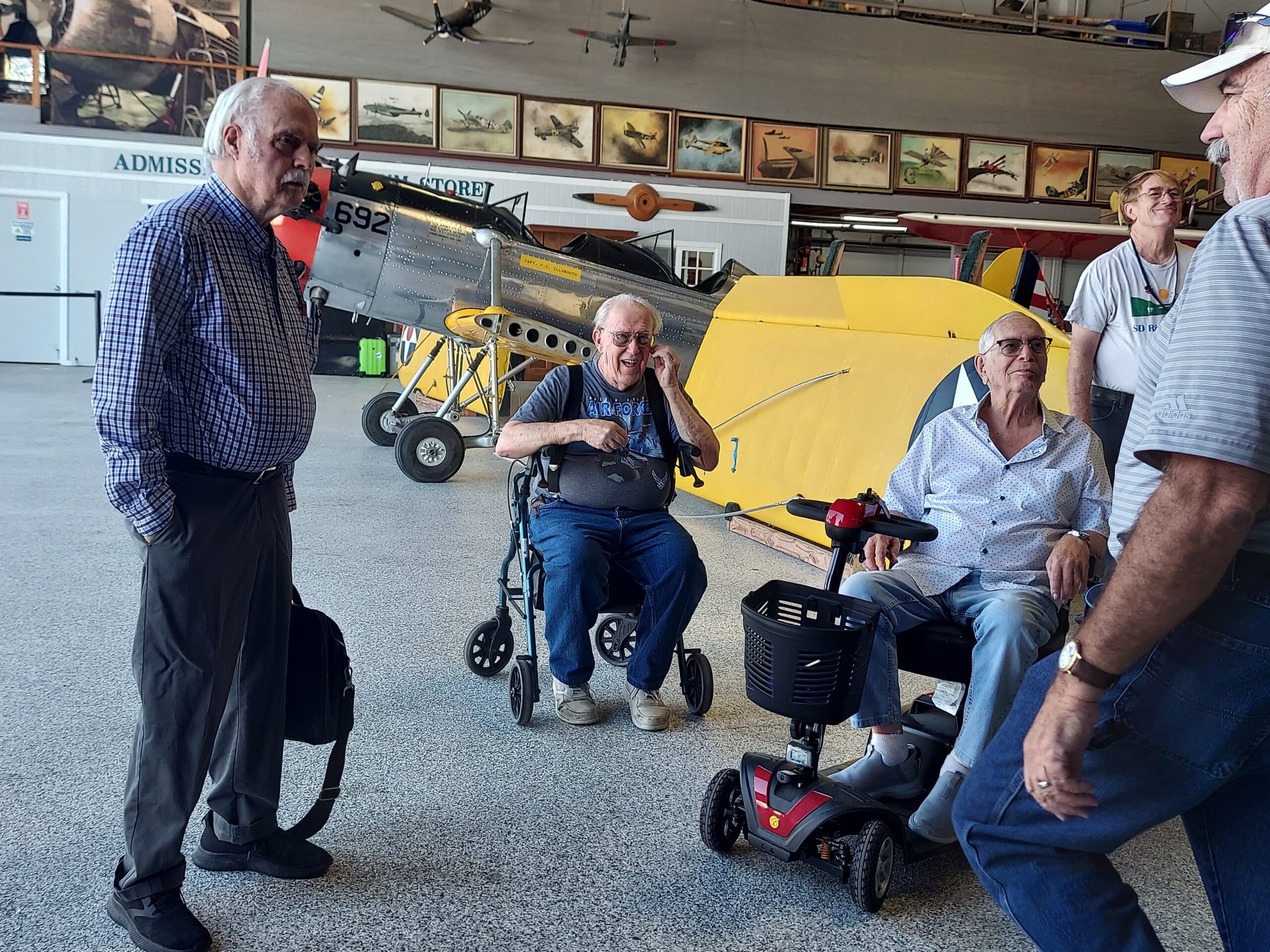 Residents interacting in a common area with aviation exhibits