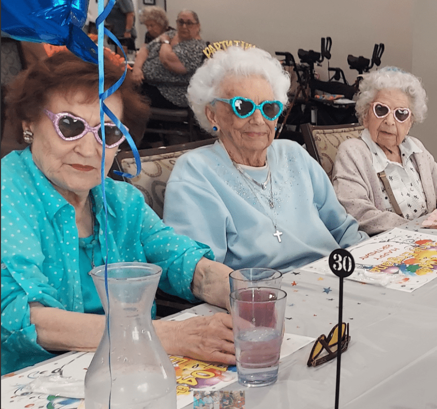 Residents enjoying a festive celebration with heart-shaped sunglasses