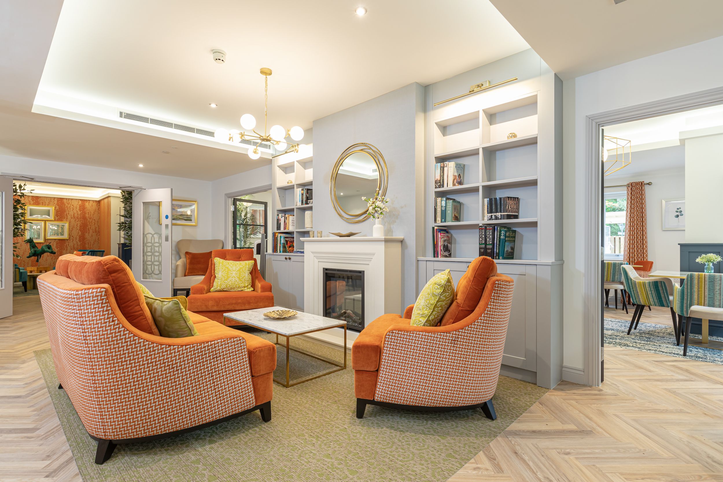 Cozy lounge area with bright orange chairs and bookshelves