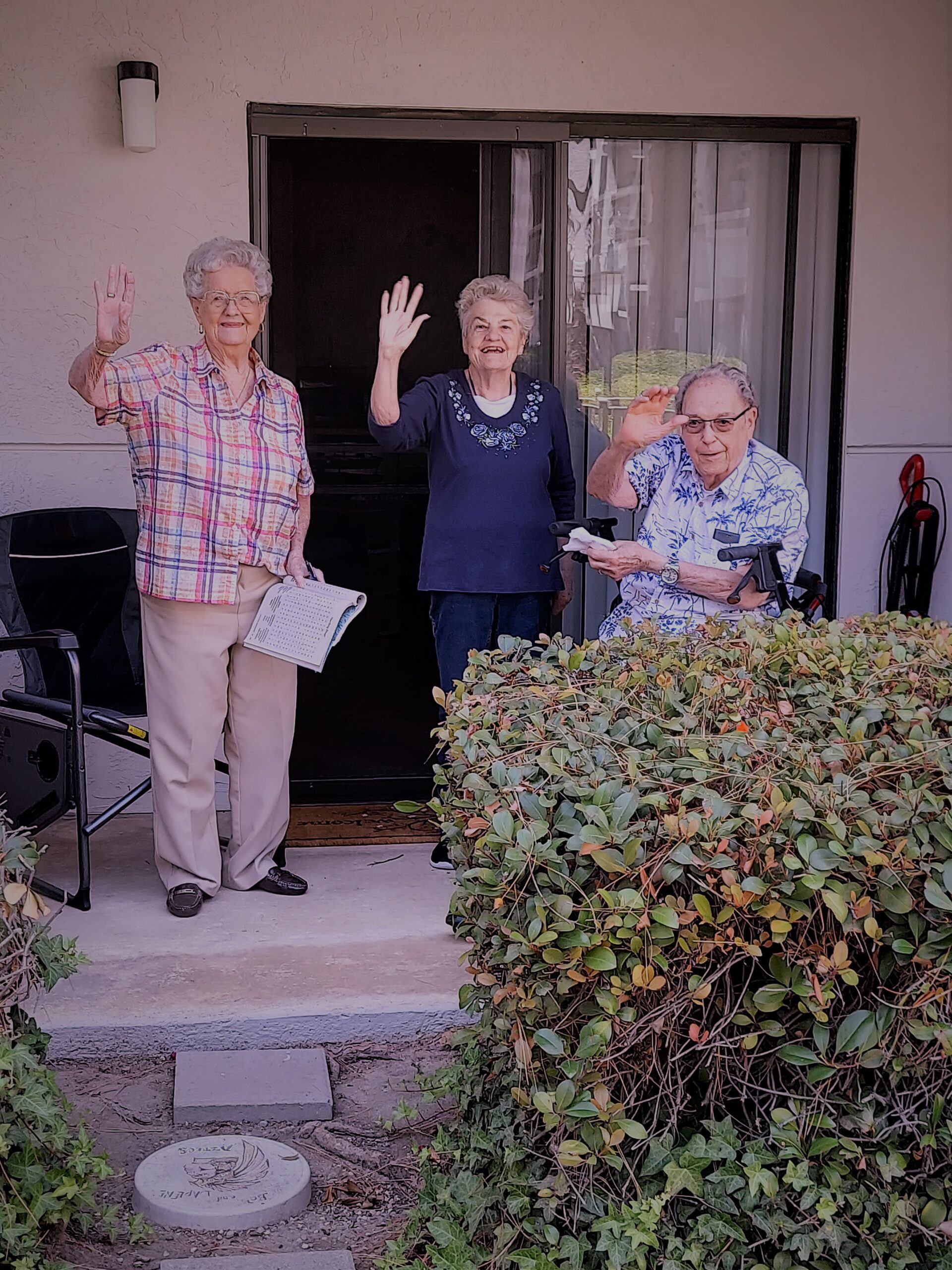 Residents waving from a patio area