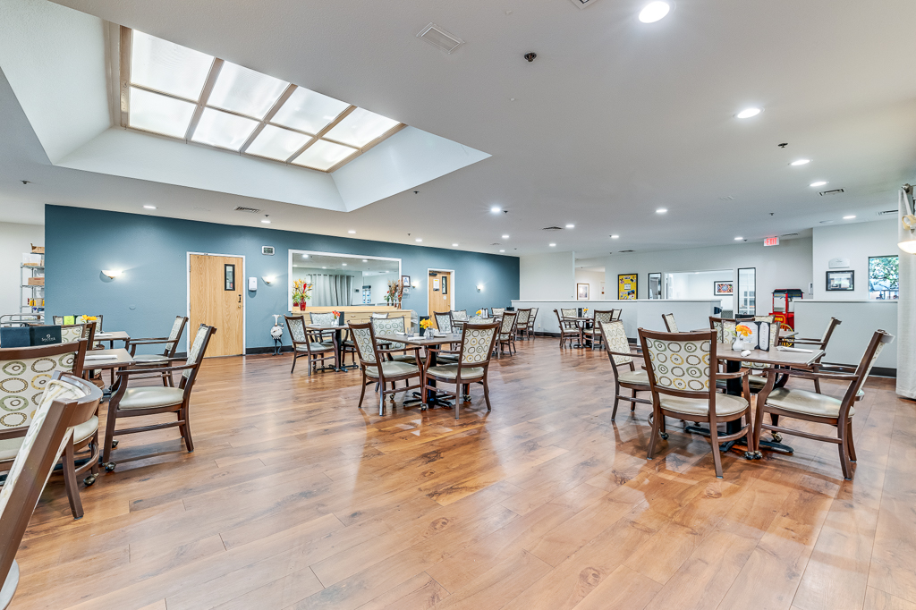 Brightly lit dining room with tables and chairs