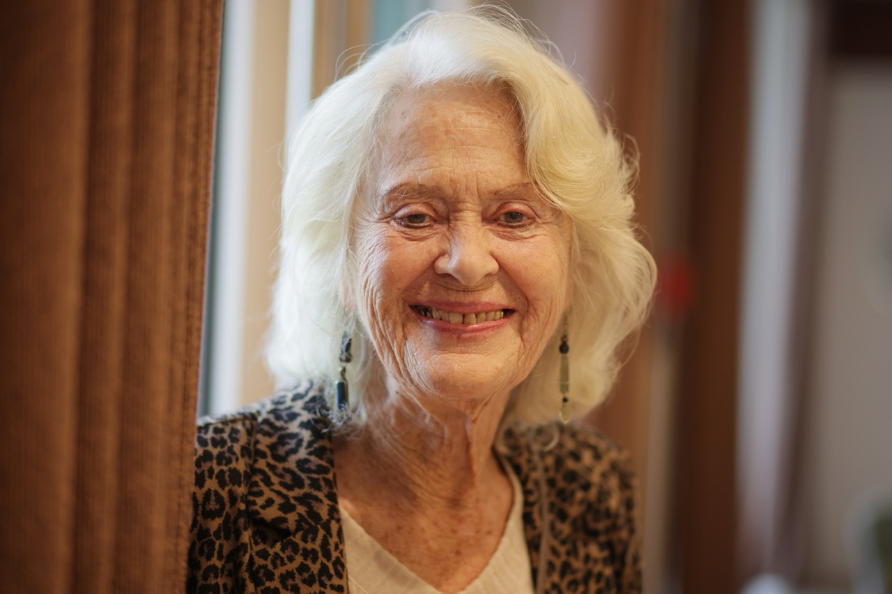 Smiling elderly woman in a warm indoor setting
