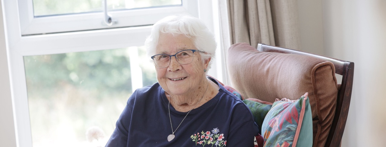 Senior resident smiling in a cozy indoor setting
