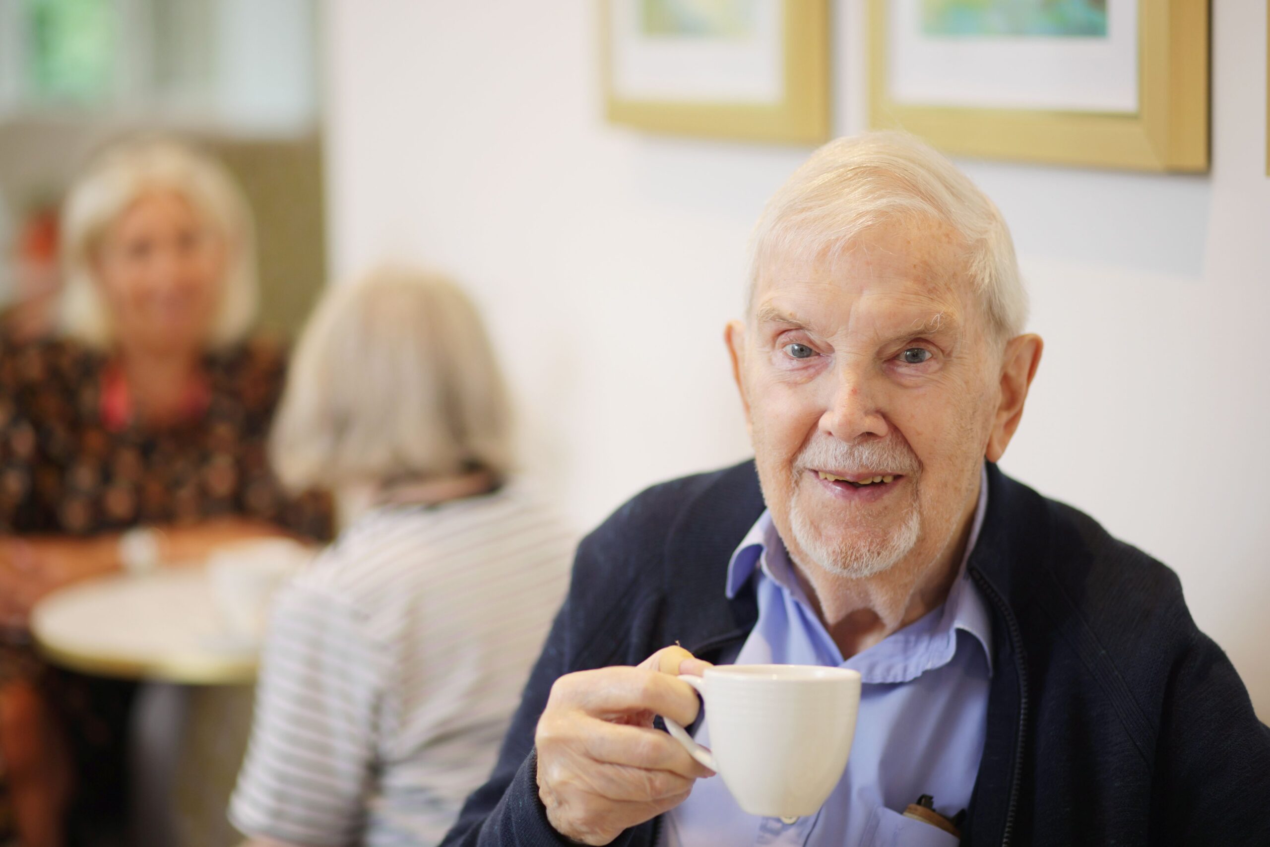 Senior resident enjoying a cup of tea in a common area
