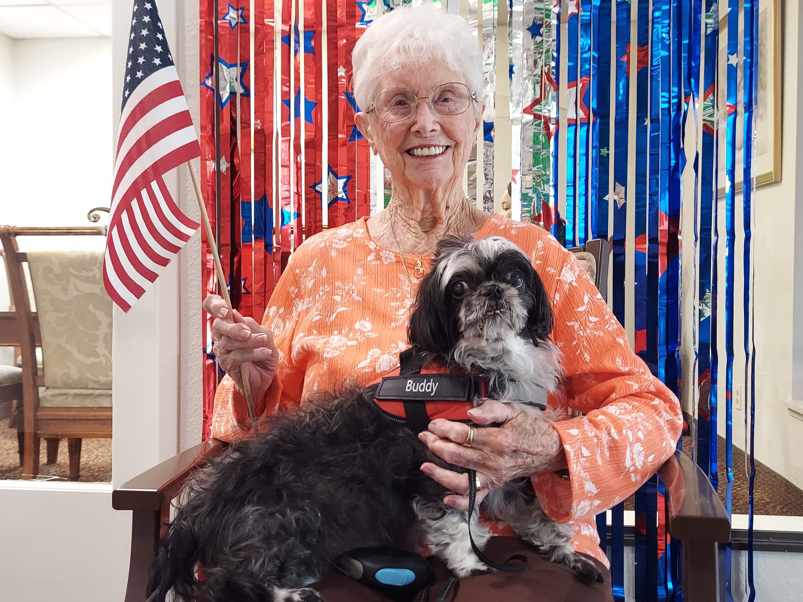 Resident with a dog in a decorated common area