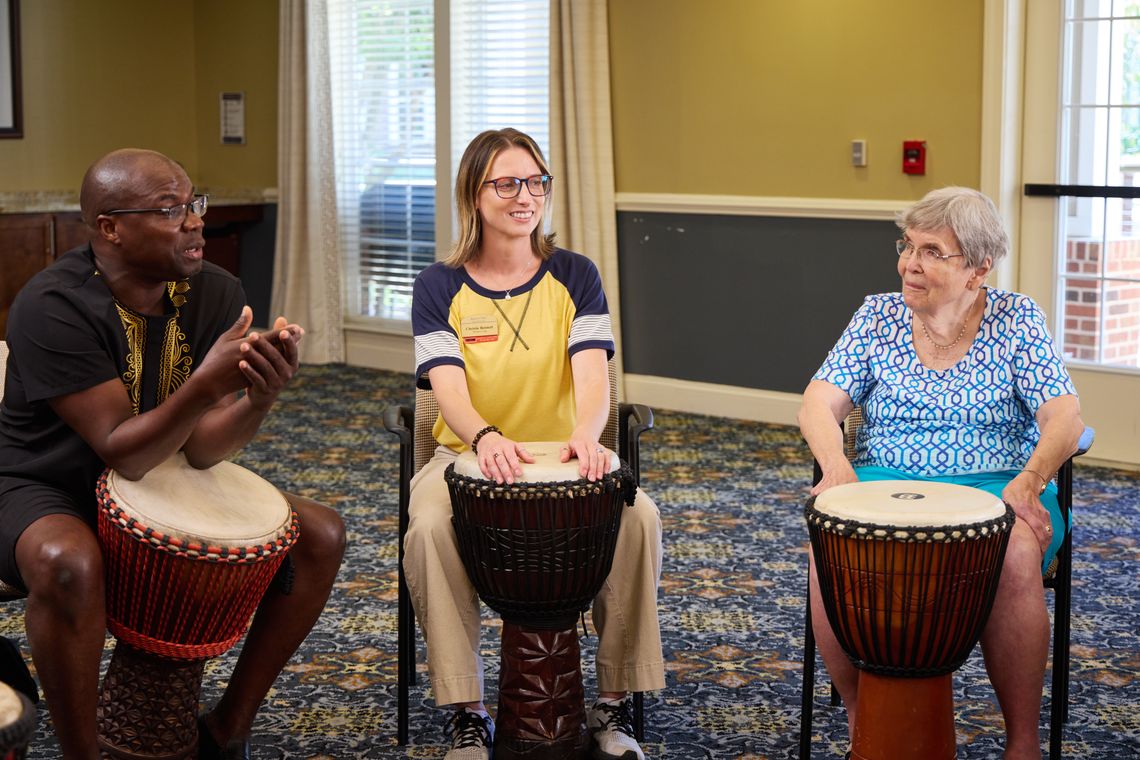 Residents and staff participating in a drum circle activity
